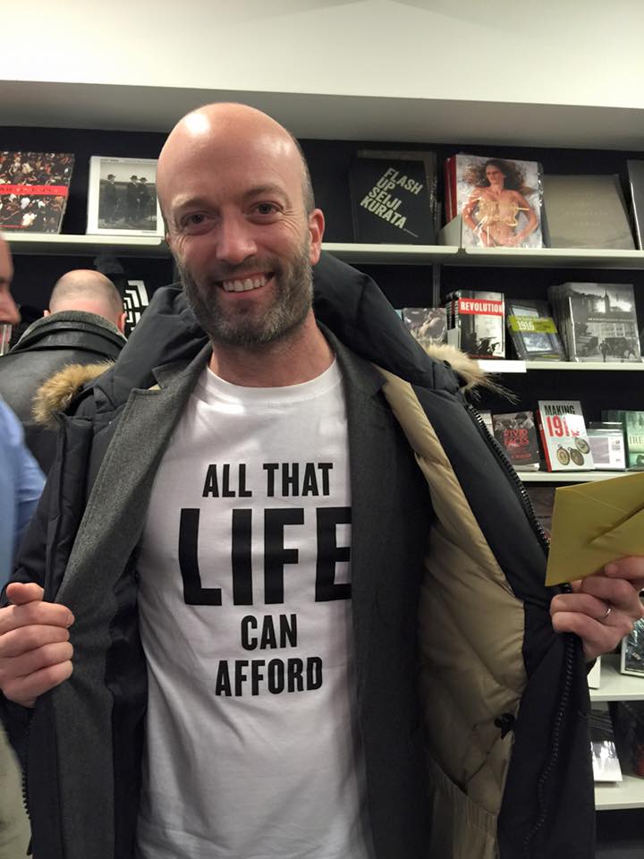 Matt Stuart at his book launch wearing shameless self promotional T-Shirt of his new books title All That Life Can Afford